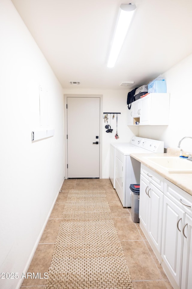 clothes washing area featuring cabinet space, light tile patterned floors, visible vents, separate washer and dryer, and a sink