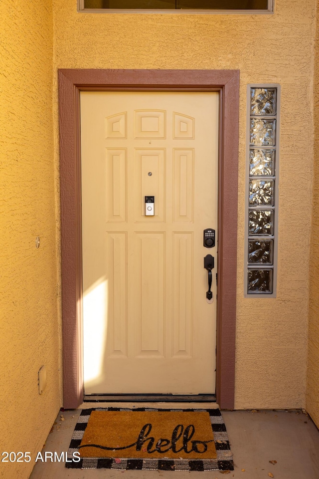 doorway to property featuring stucco siding