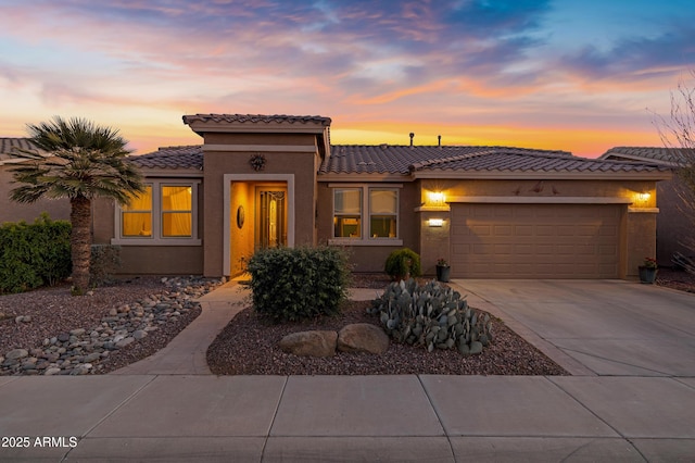 view of front of home featuring concrete driveway, a garage, and stucco siding
