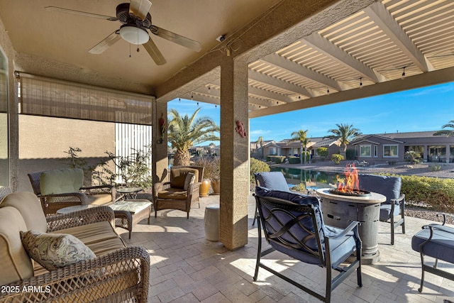 view of patio / terrace featuring ceiling fan, an outdoor living space with a fire pit, and a pergola