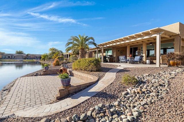 exterior space with a water view, a pergola, and a patio