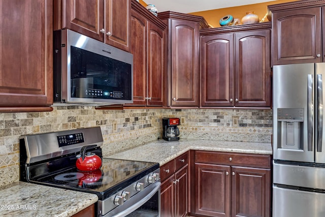 kitchen featuring light stone countertops, appliances with stainless steel finishes, and tasteful backsplash