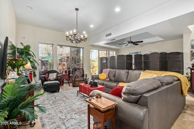 living area with recessed lighting, visible vents, a tray ceiling, and ceiling fan with notable chandelier