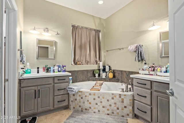 full bath featuring a garden tub, tile patterned flooring, and two vanities