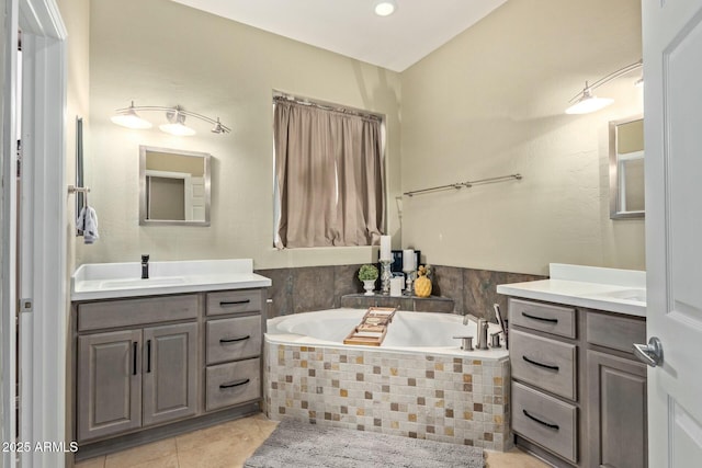 full bathroom with a garden tub, two vanities, a sink, and tile patterned flooring