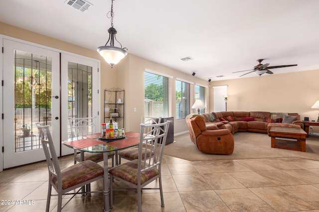 dining area with light tile patterned floors, ceiling fan, and french doors