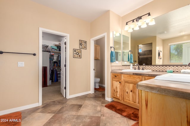 bathroom featuring vanity, toilet, and decorative backsplash