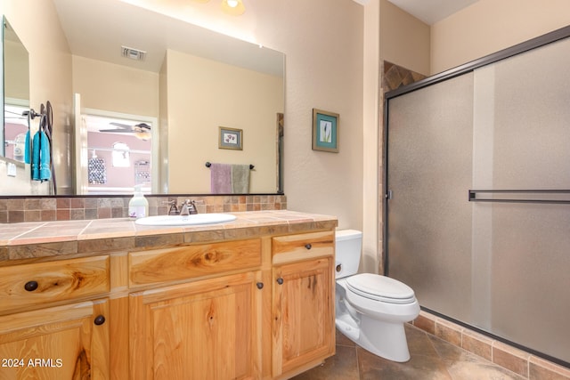 bathroom with tile patterned flooring, vanity, toilet, and an enclosed shower