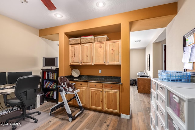 home office featuring light wood-type flooring, a textured ceiling, ceiling fan, and built in desk