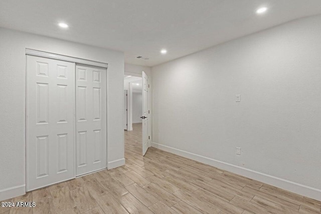 unfurnished bedroom featuring light wood-type flooring and a closet