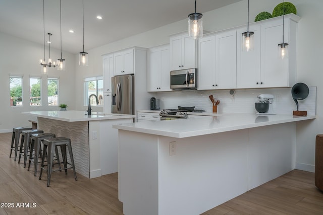 2345 N 28th Pl, Phoenix, AZ 85008 - kitchen featuring stainless steel appliances, light wood-style floors, decorative backsplash, recessed lighting, and a kitchen bar