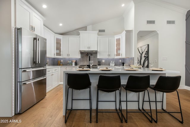8419 E Rancho Vista Dr, Scottsdale, AZ 85251 - kitchen featuring decorative backsplash, lofted ceiling, visible vents, and freestanding refrigerator
