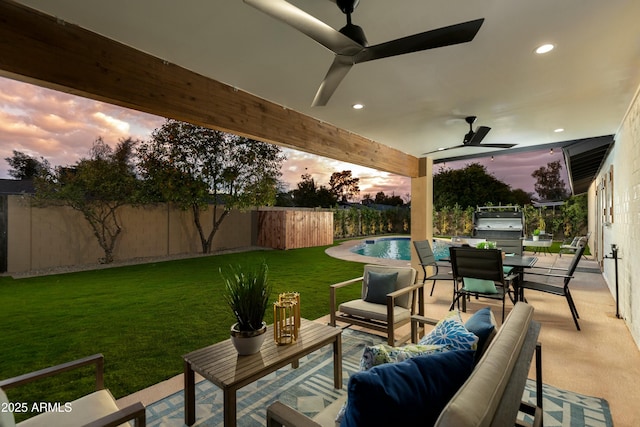 8419 E Rancho Vista Dr, Scottsdale, AZ 85251 - patio terrace at dusk with an outdoor hangout area, outdoor dining space, ceiling fan, fence private yard, and a lawn