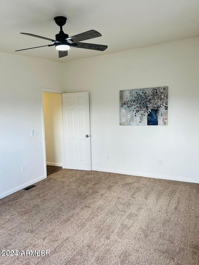 carpeted spare room with ceiling fan