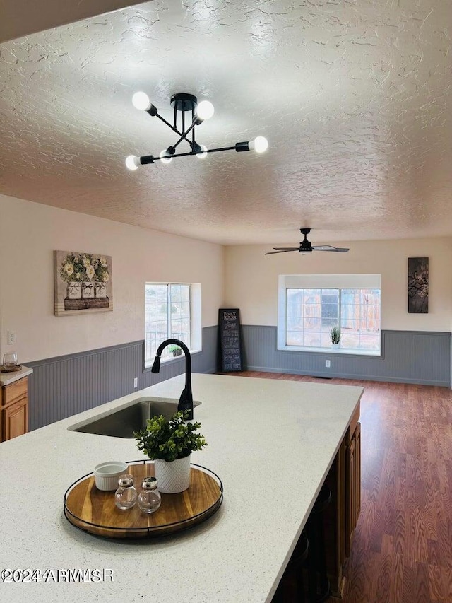 kitchen featuring sink, dark hardwood / wood-style flooring, a textured ceiling, and ceiling fan