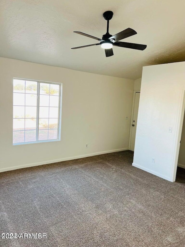 unfurnished bedroom with a textured ceiling, ceiling fan, and carpet