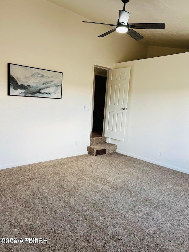 carpeted spare room with lofted ceiling and ceiling fan