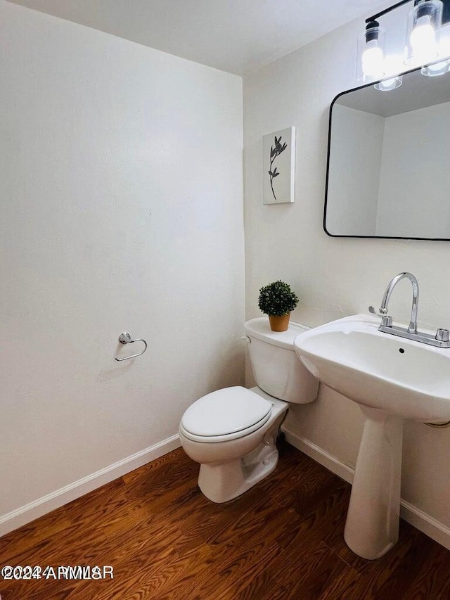 bathroom with sink, toilet, and hardwood / wood-style flooring