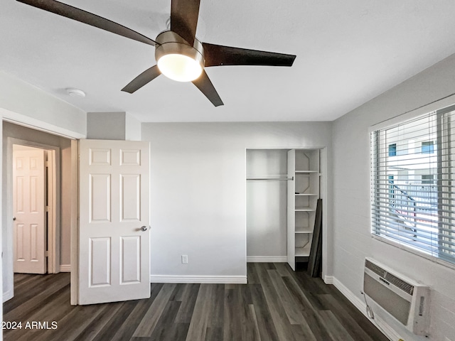 unfurnished bedroom featuring dark hardwood / wood-style flooring, a closet, a wall mounted air conditioner, and ceiling fan