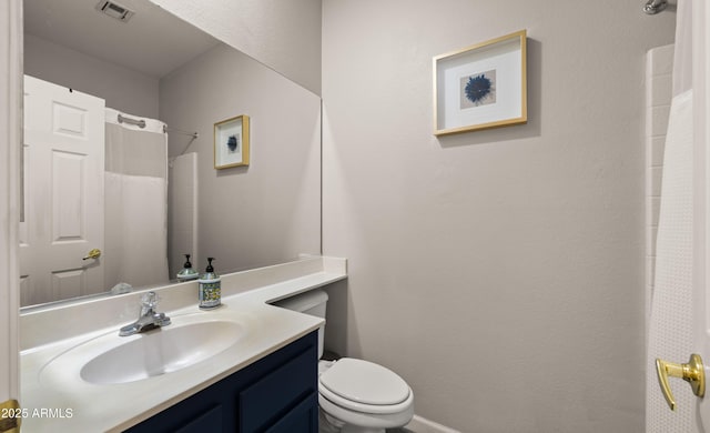 bathroom with toilet, vanity, and curtained shower