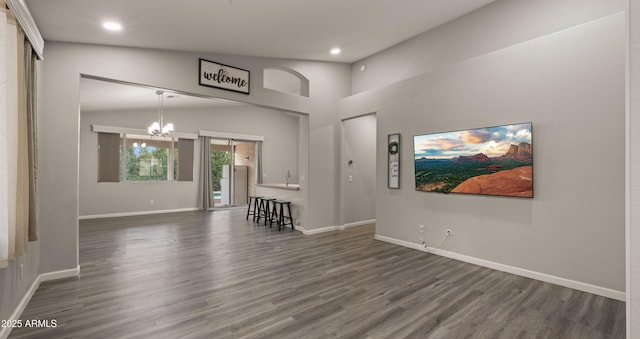 living room featuring a notable chandelier, lofted ceiling, and dark hardwood / wood-style floors