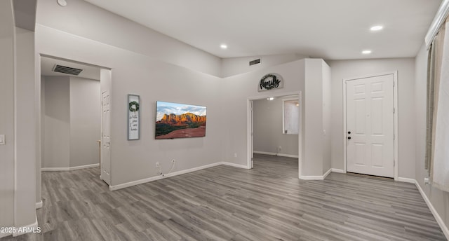 unfurnished room featuring vaulted ceiling and light hardwood / wood-style floors