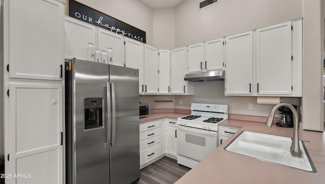 kitchen with dark hardwood / wood-style floors, appliances with stainless steel finishes, white cabinetry, and sink