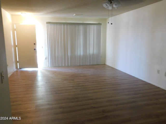 unfurnished room with ceiling fan and dark hardwood / wood-style flooring