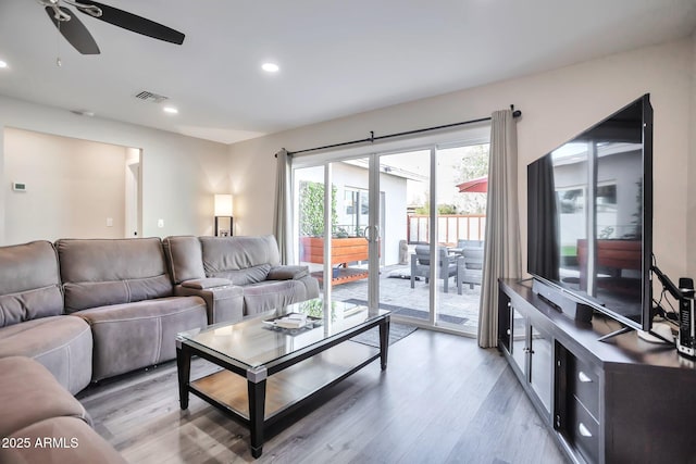 living area with ceiling fan, recessed lighting, visible vents, and light wood-style floors