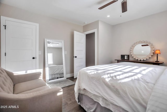 bedroom with dark wood finished floors, a ceiling fan, and baseboards