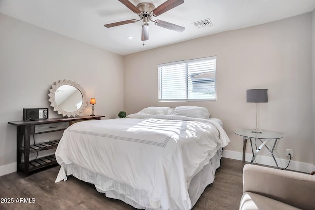bedroom with baseboards, visible vents, dark wood finished floors, and a ceiling fan