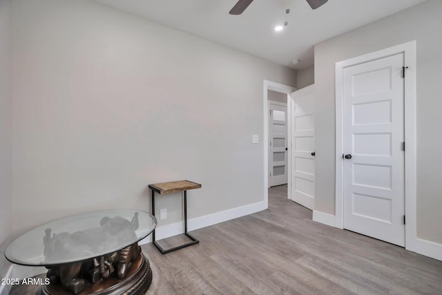 interior space with recessed lighting, wood finished floors, a ceiling fan, and baseboards