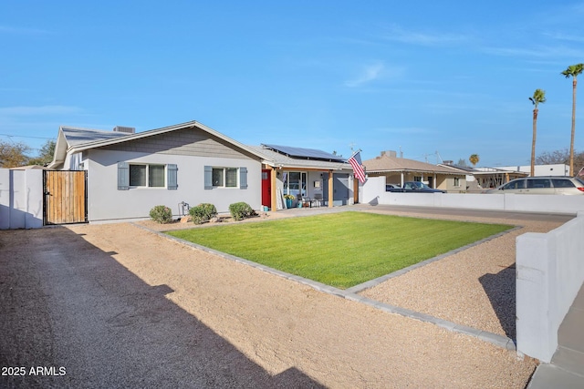 ranch-style house with a front yard, a gate, fence, and solar panels