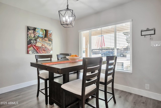 dining room featuring baseboards, a chandelier, and wood finished floors