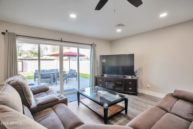 living room featuring baseboards, visible vents, a ceiling fan, light wood-style floors, and recessed lighting