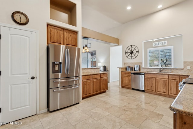 kitchen with tasteful backsplash, recessed lighting, appliances with stainless steel finishes, brown cabinetry, and a sink