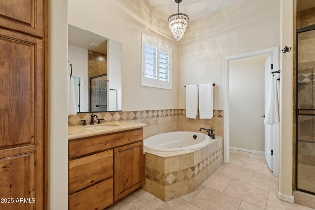 full bathroom featuring vanity, an inviting chandelier, a stall shower, tile patterned flooring, and a bath