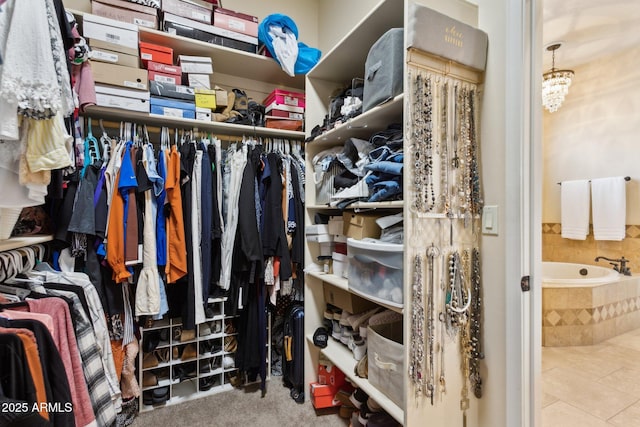 spacious closet featuring tile patterned flooring and a notable chandelier