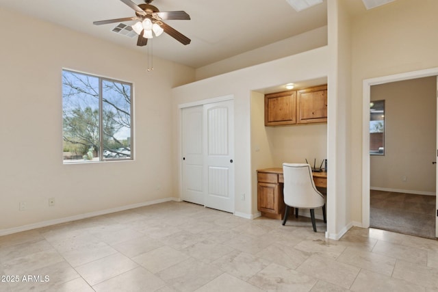 unfurnished office with visible vents, baseboards, a ceiling fan, and built in desk