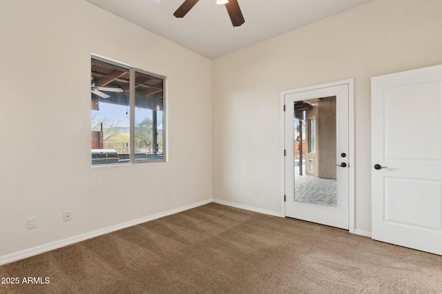 carpeted empty room featuring ceiling fan and baseboards