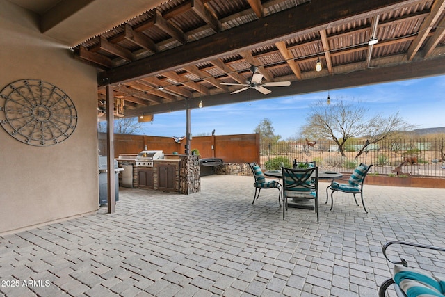 view of patio featuring outdoor dining space, fence, area for grilling, ceiling fan, and a grill