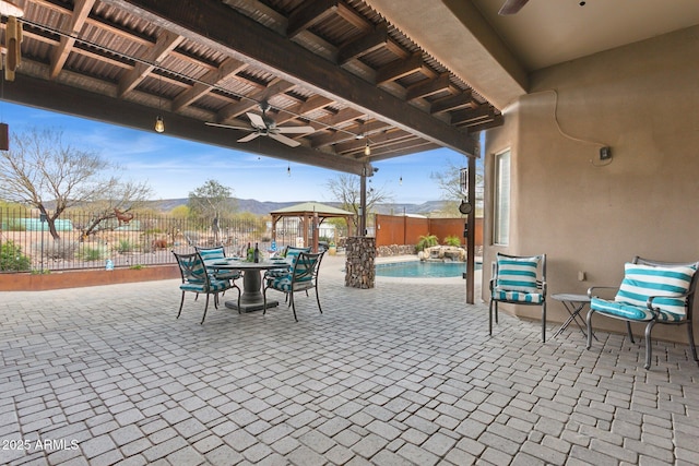 view of patio / terrace featuring a gazebo, fence, a fenced in pool, and ceiling fan