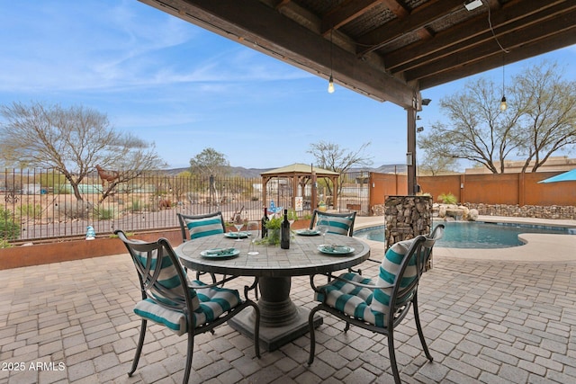 view of patio with outdoor dining space, a fenced in pool, and fence private yard