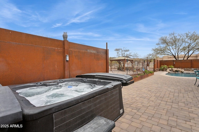 view of patio featuring fence, a fenced in pool, and a hot tub