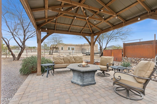 view of patio featuring a gazebo, fence, and an outdoor fire pit