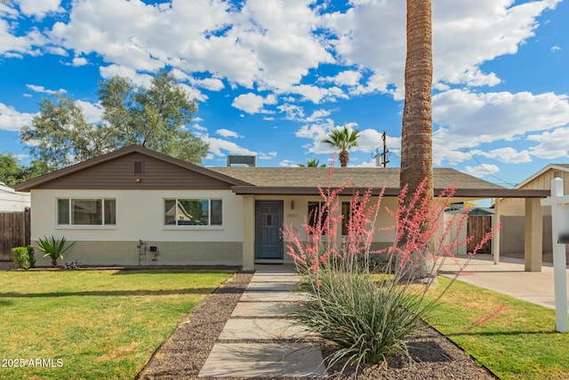single story home with fence, roof with shingles, brick siding, a front yard, and a carport