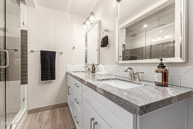 bathroom with double vanity, a sink, and a shower stall