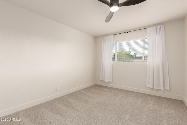 spare room featuring baseboards, light colored carpet, and ceiling fan