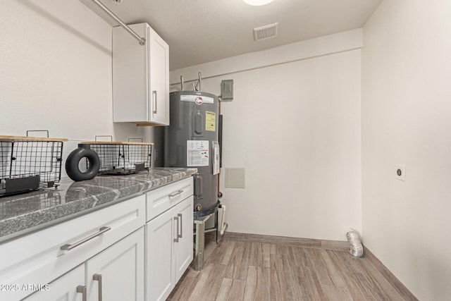 clothes washing area with light wood-style floors, laundry area, electric dryer hookup, visible vents, and water heater