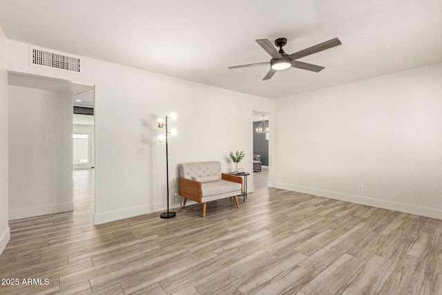 living area with ceiling fan, visible vents, baseboards, and light wood finished floors